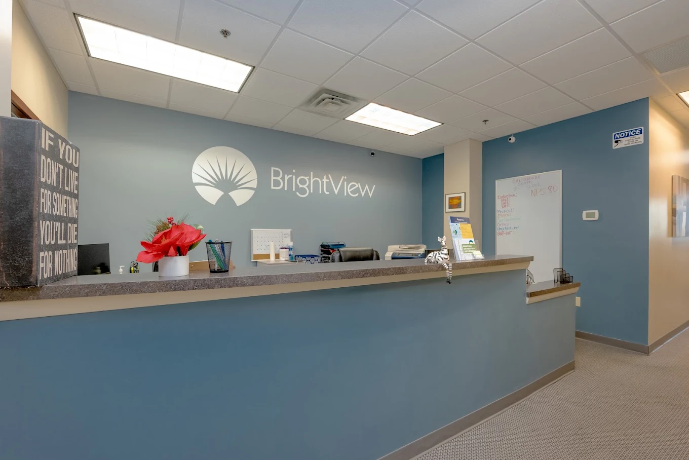 Blue reception desk with BrightView logo on the wall