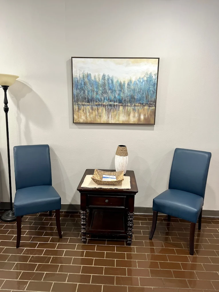 Two blue chairs beside a table with decorative items