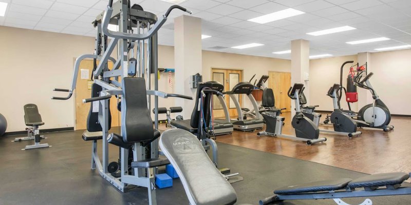 A well-equipped fitness center featuring various exercise machines, including treadmills, stationary bikes, and strength training equipment.