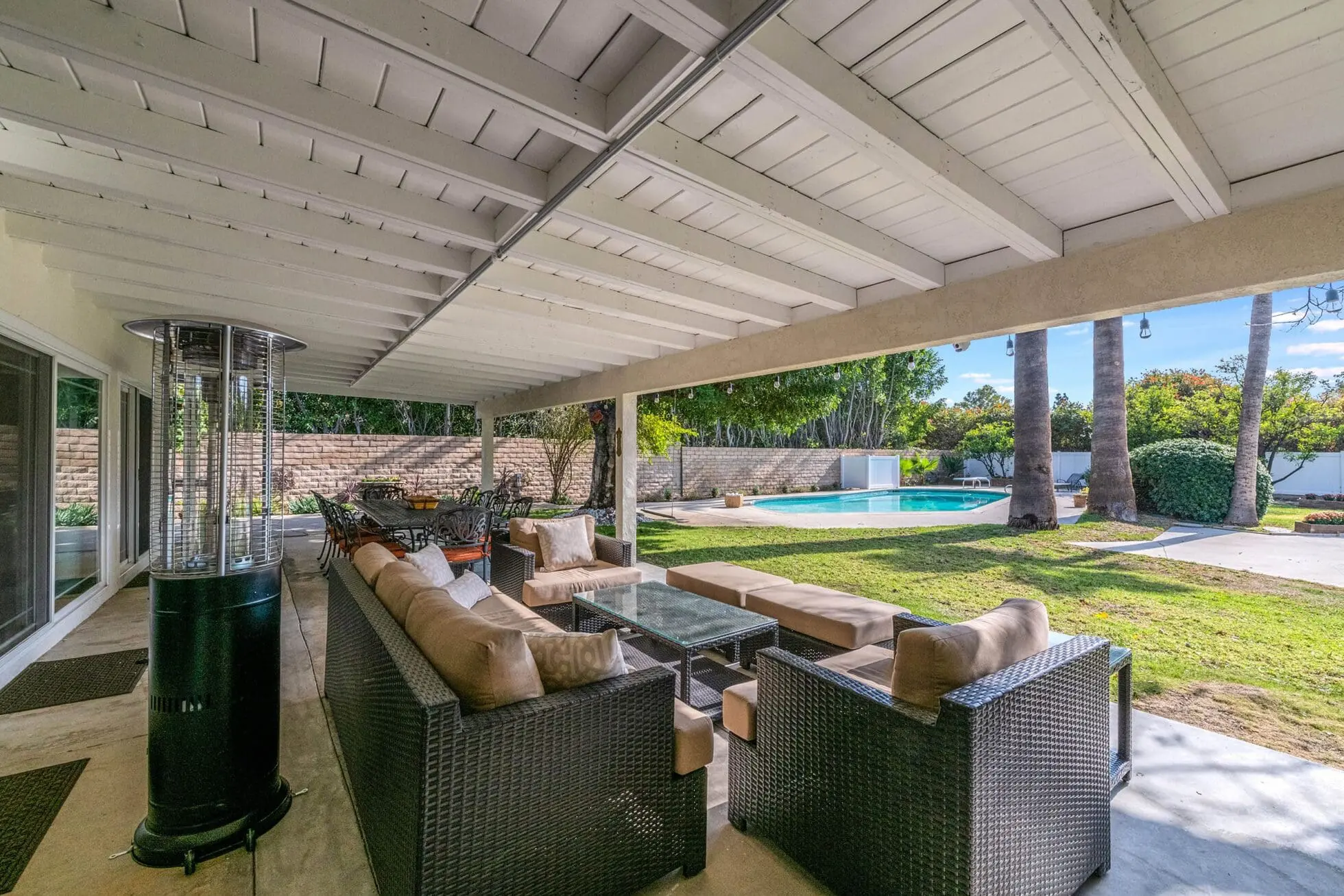 Covered patio with cushioned seating and pool view