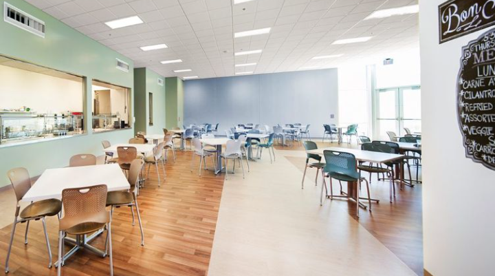 Spacious dining area with tables and cafeteria serving window