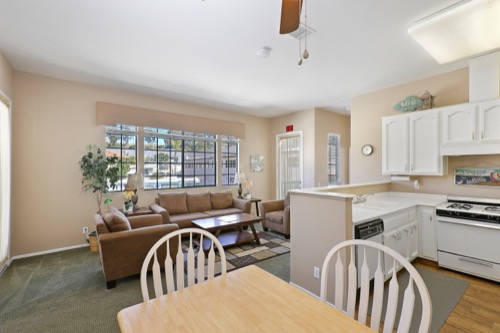 Kitchen with white cabinets open to dining and seating area