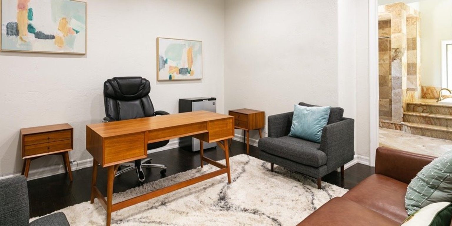 Private therapy office with desk, chairs, and modern decor