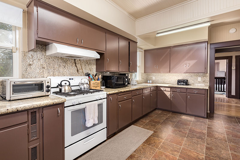 Communal kitchen with stove, cabinets, and prep space