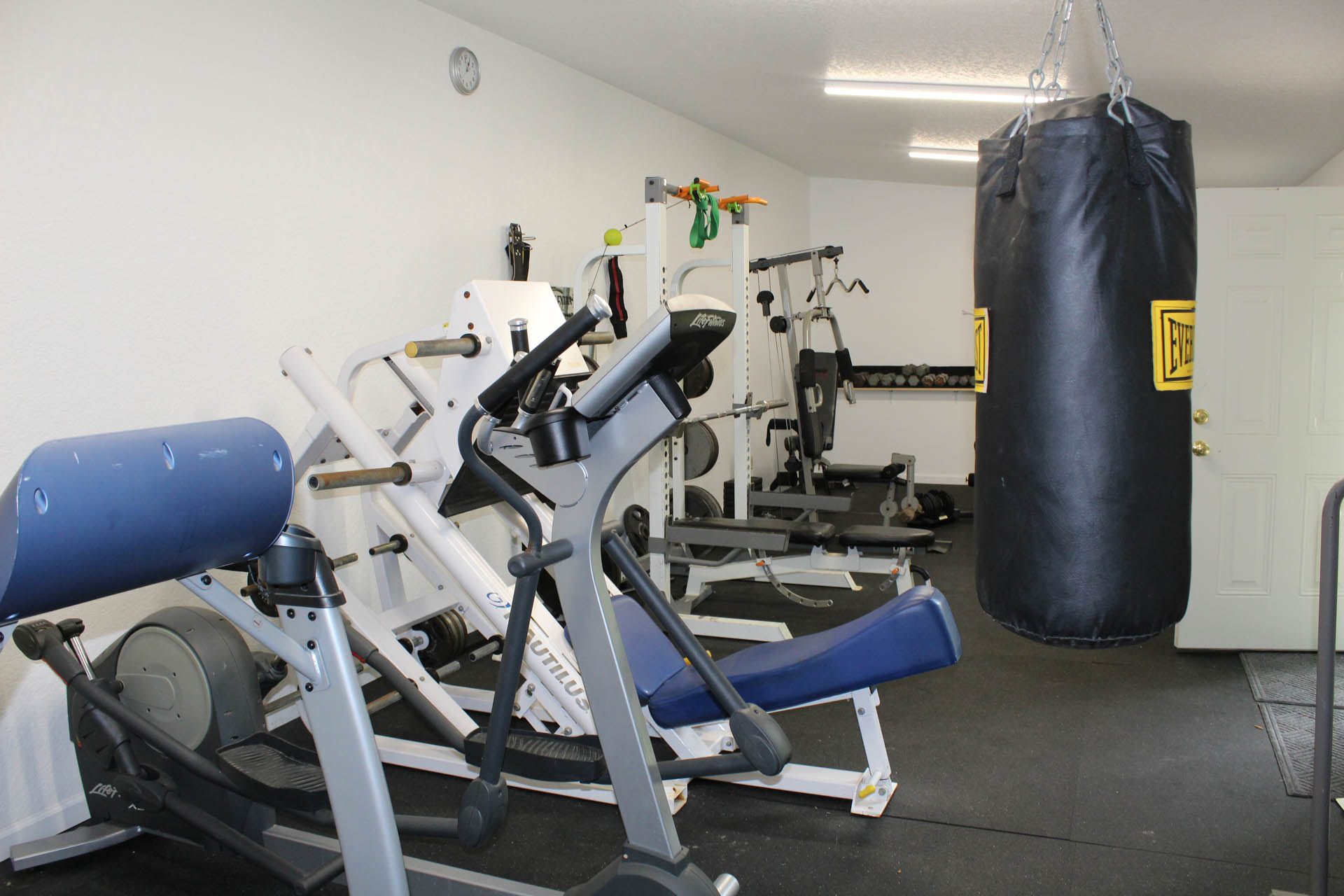 On-site fitness center with weight machines and punching bag