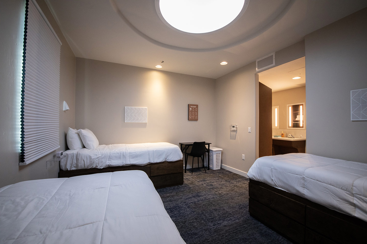 Shared bedroom with twin beds, desk, and attached bathroom
