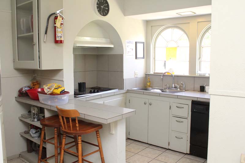 Small white kitchen with arched alcove and counter seating