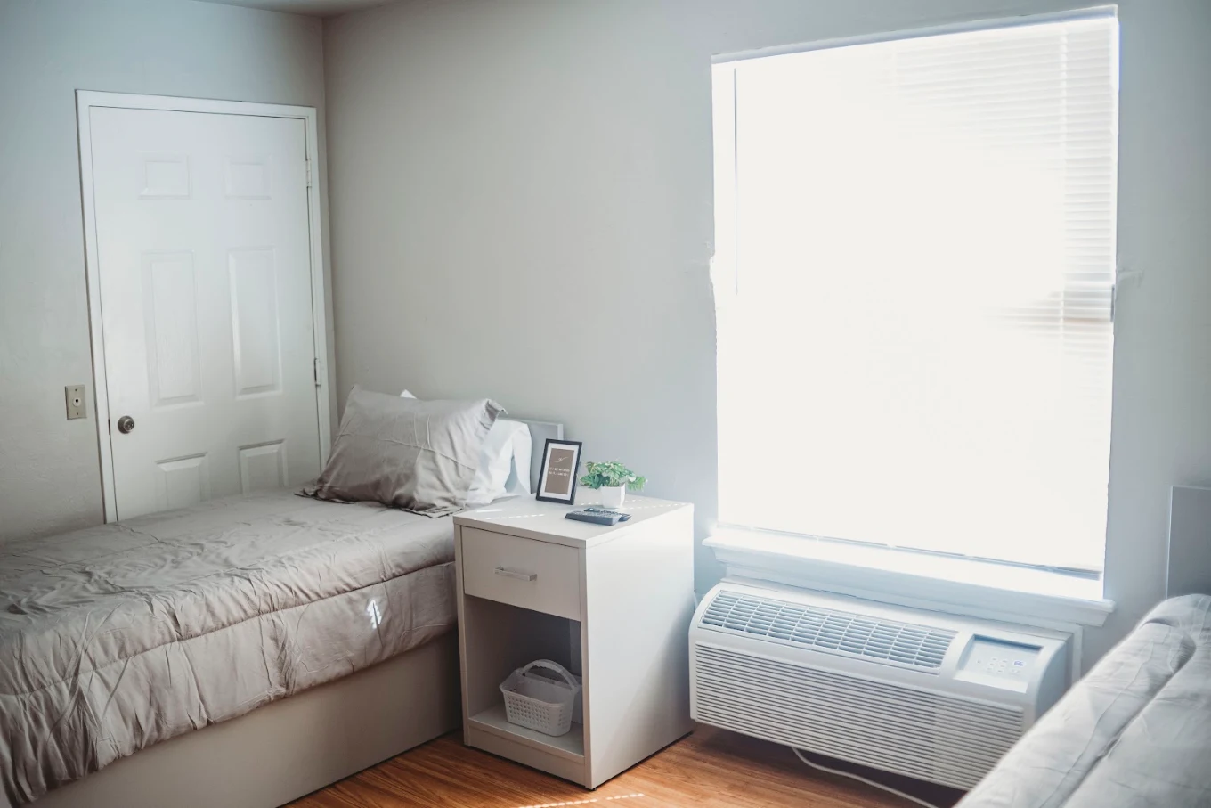 Shared bedroom with two beds, nightstand, and large window