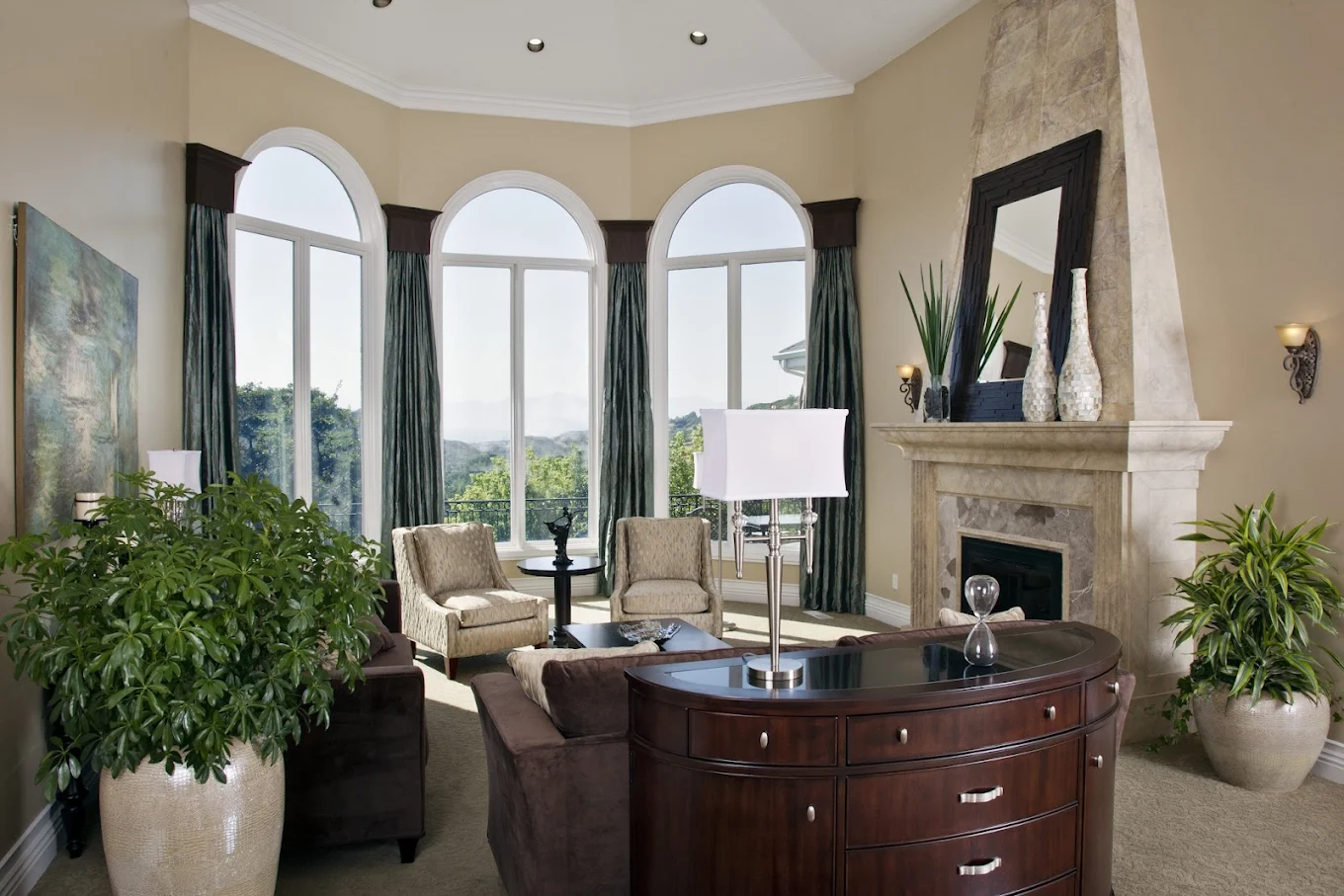 Lounge with fireplace and large windows overlooking hill