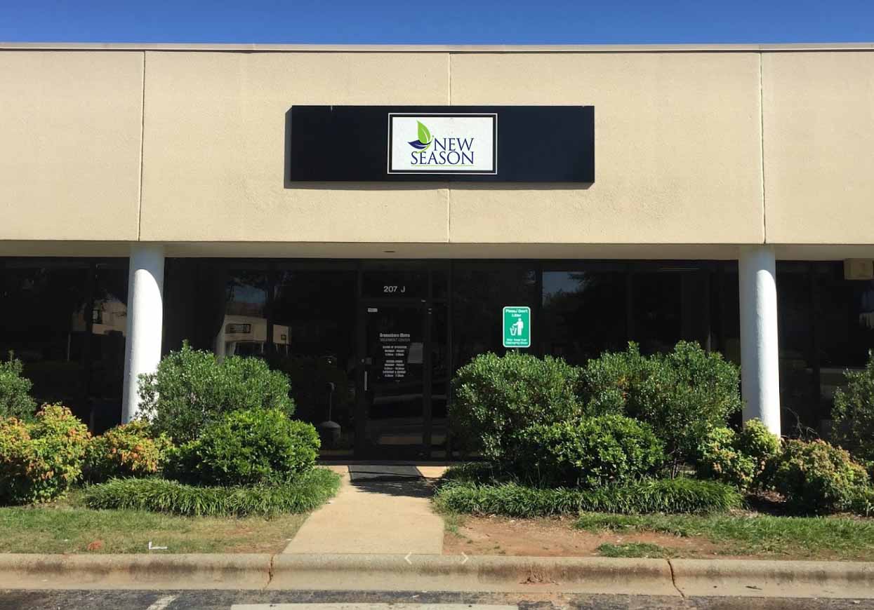 Main entrance with bushes and center sign