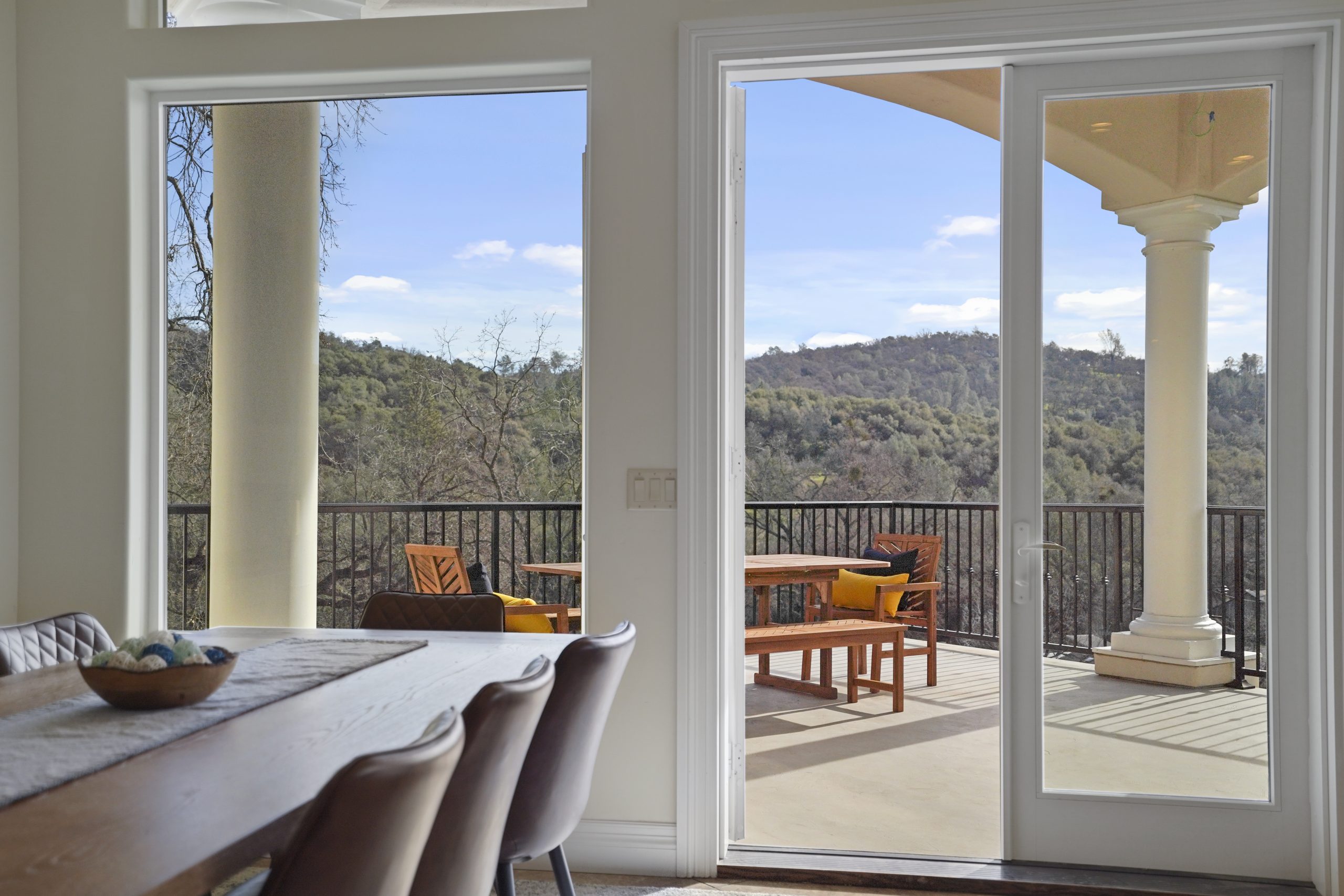 Dining area with doors opening to a scenic outdoor terrace.