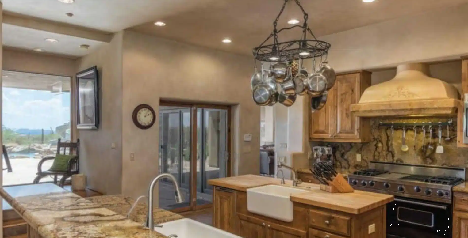 Spacious kitchen with wood cabinets and hanging cookware