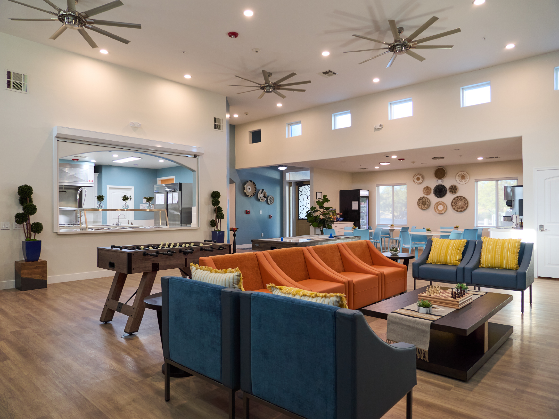 Open lounge with seating, games, and dining area in background.