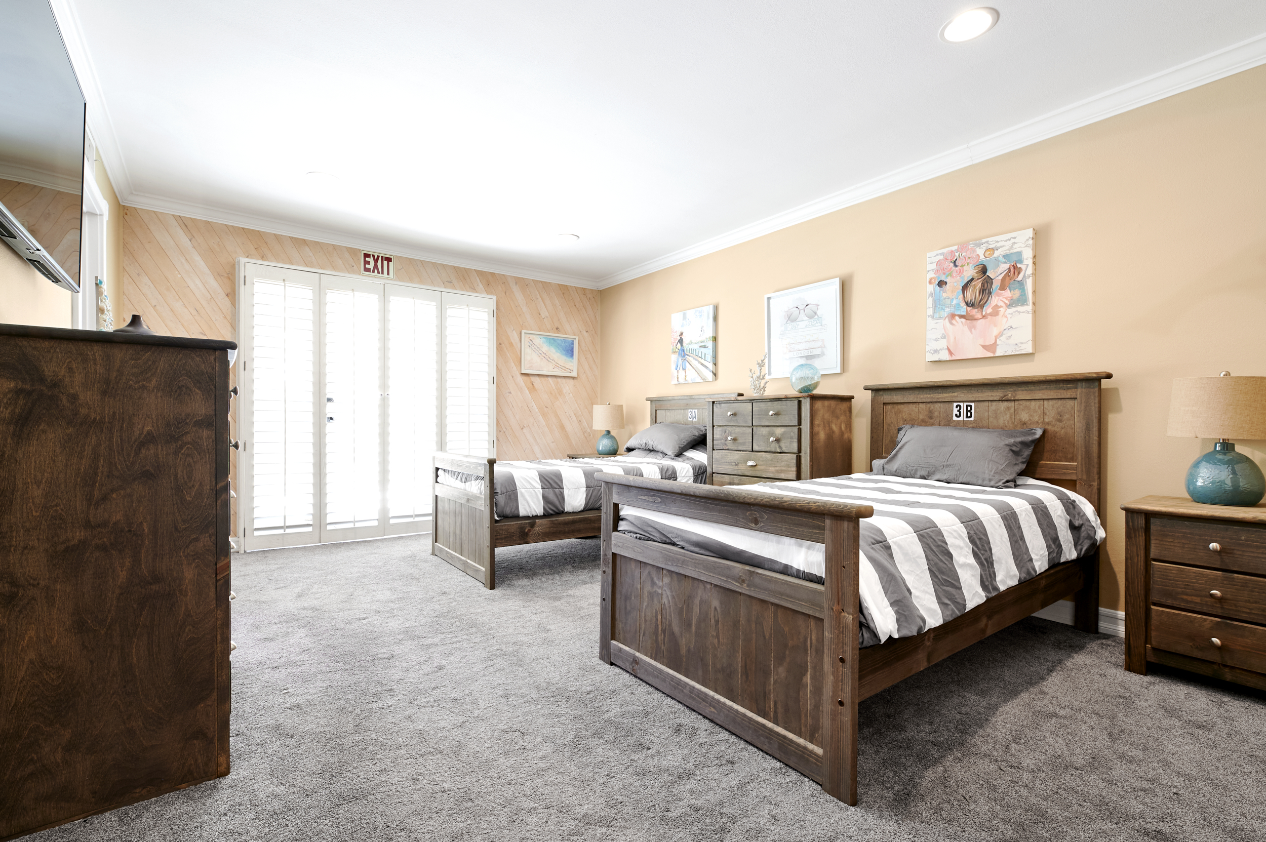 Shared bedroom with twin beds and dressers.