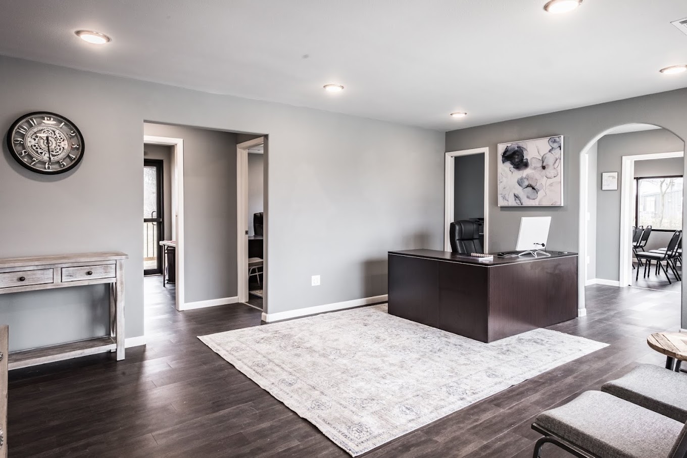 Office space with large desk, wall art, and arched doorways