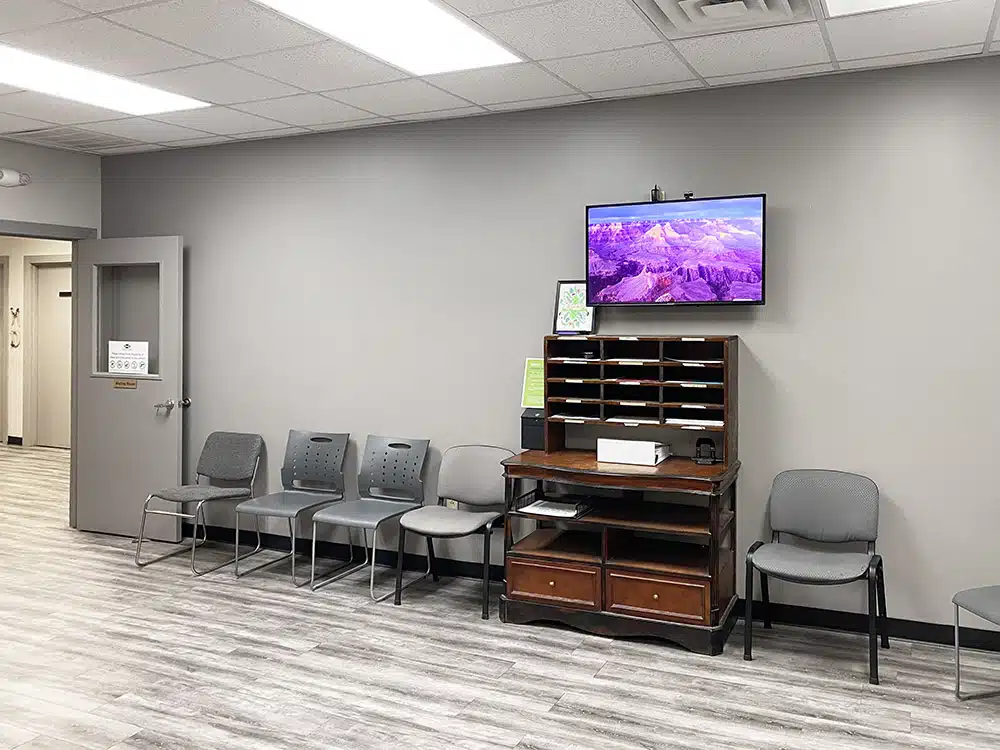 Waiting area with chairs and TV above wooden cabinet