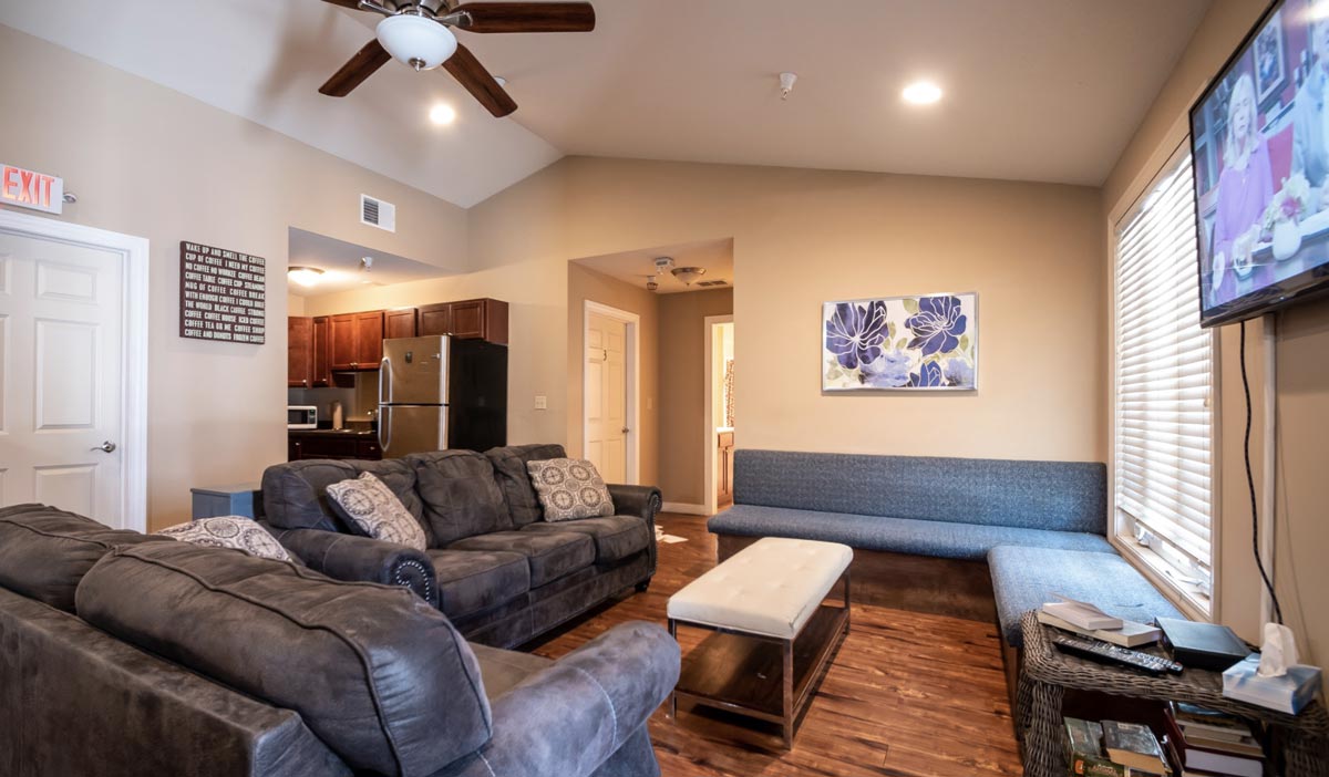 Common room with sofas, TV, and full kitchen