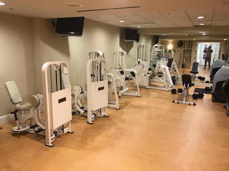 A fitness room with exercise machines and weights.
