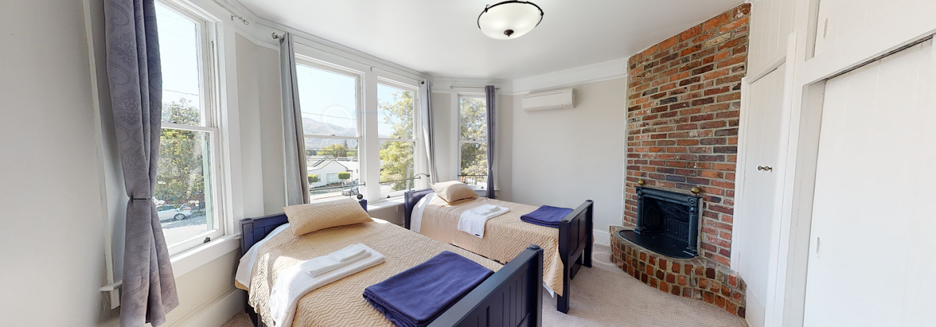 Bedroom with twin beds, fireplace, and large windows