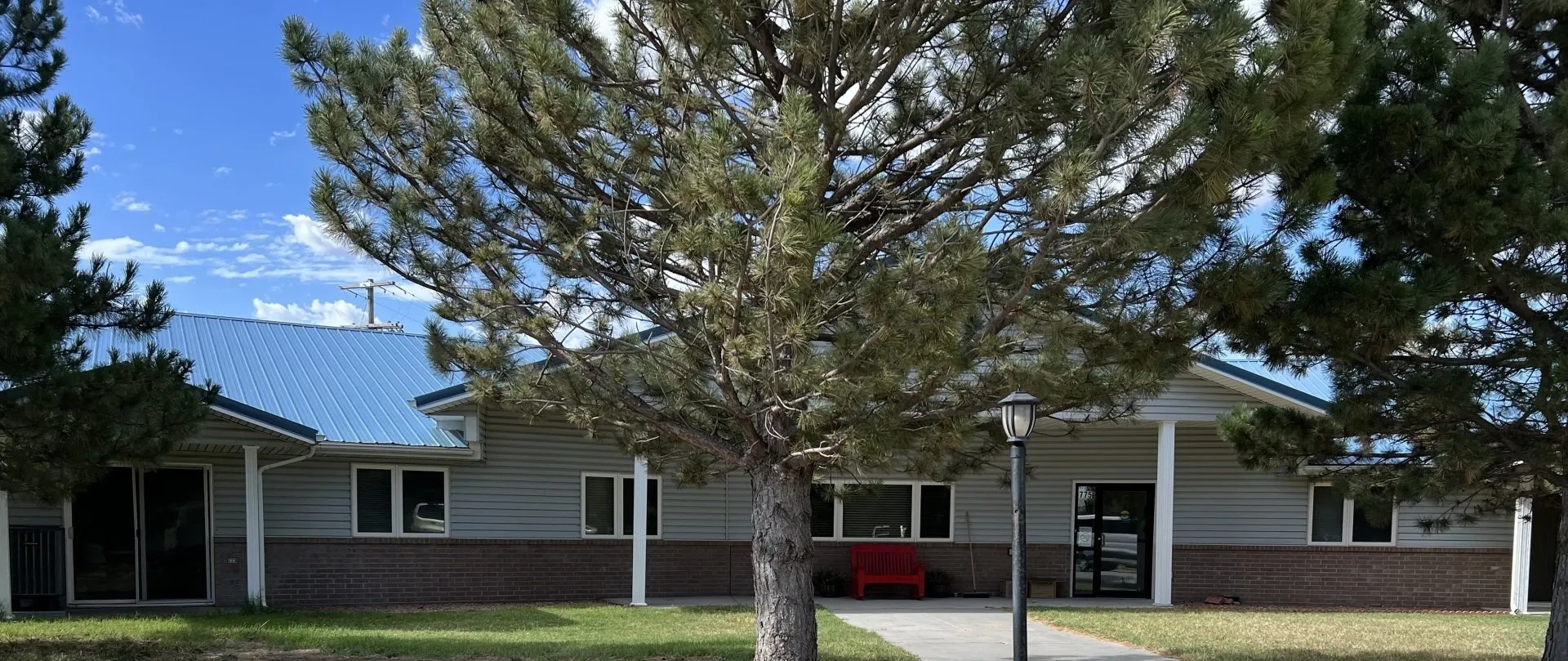 Residential treatment facility exterior with front walkway and trees