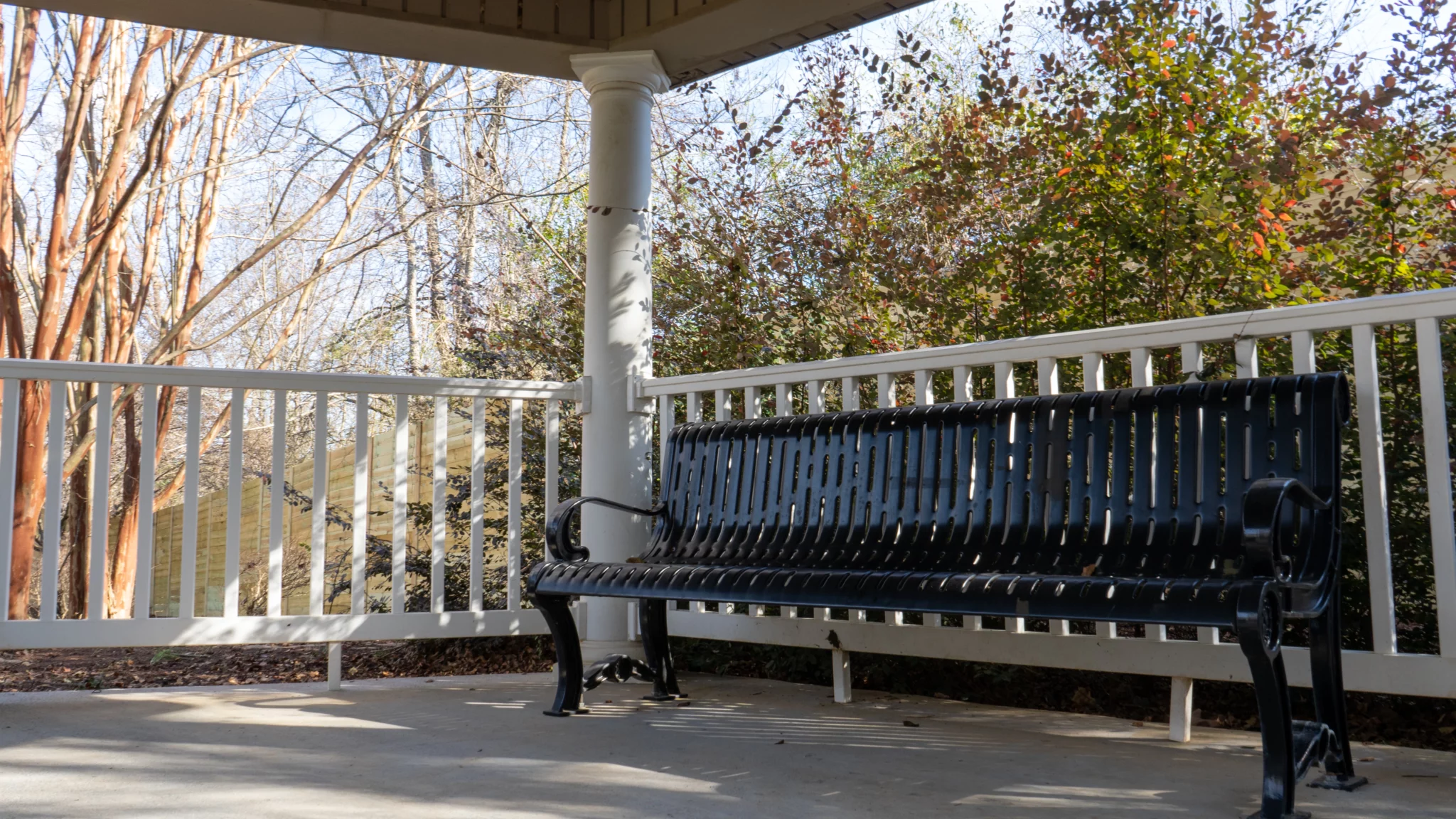 Covered patio with bench seating and white railing