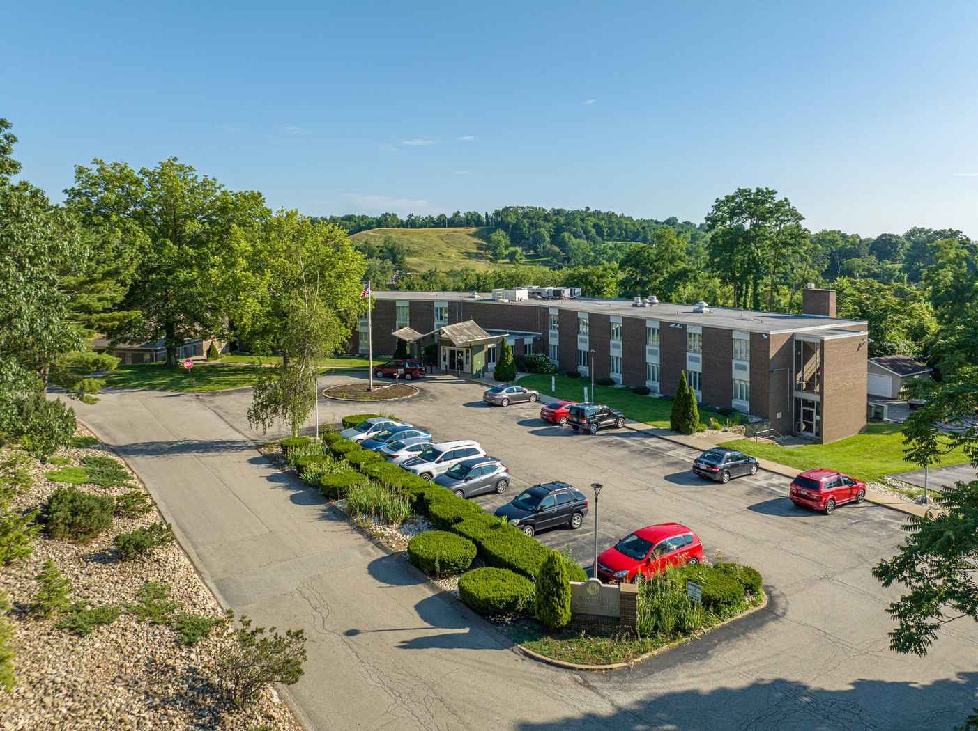 Two-story rehab facility with parking lot and scenic hills