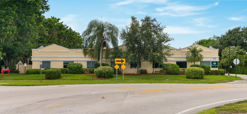 Facility street view with signage on wall. 