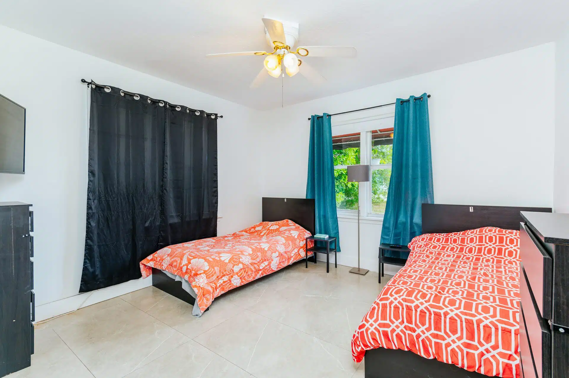 Two twin beds in a bright shared room with curtains and nightstands