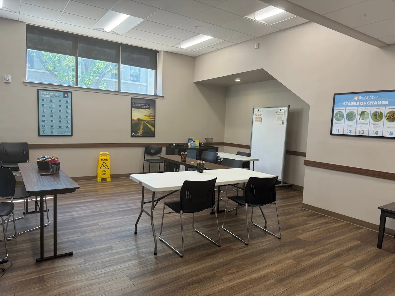 Group therapy room with tables, chairs, and whiteboard