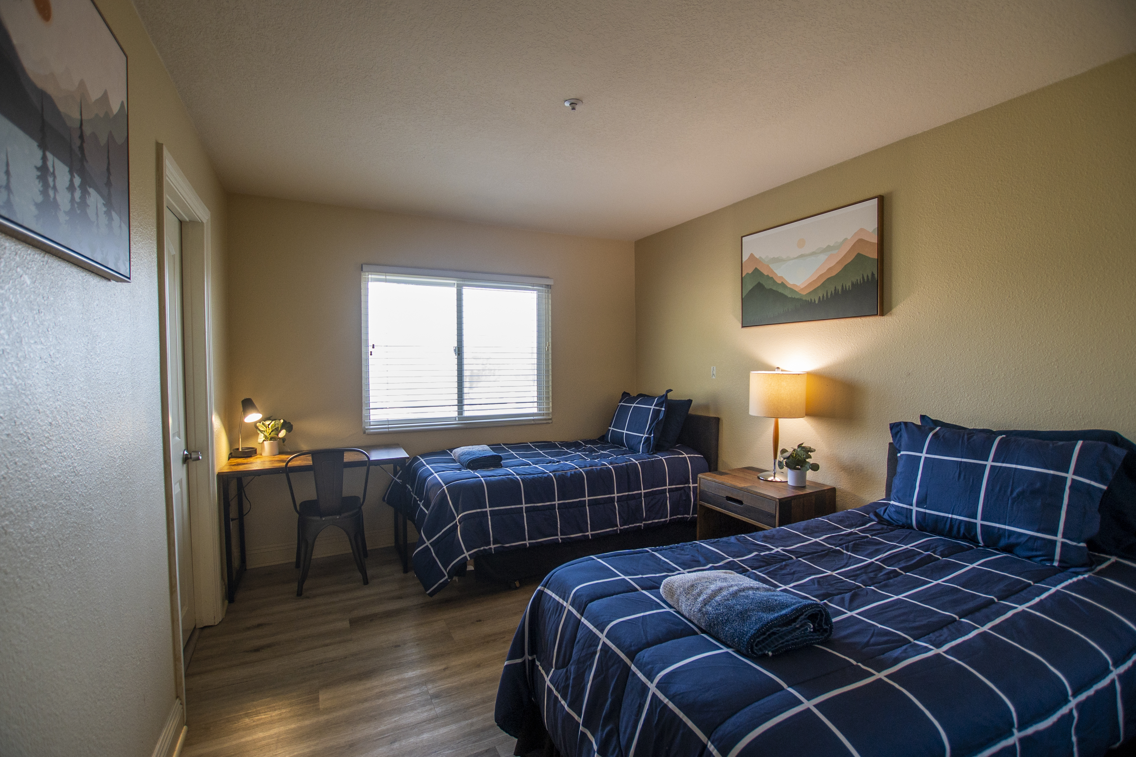 Two twin beds with checkered bedding and desk