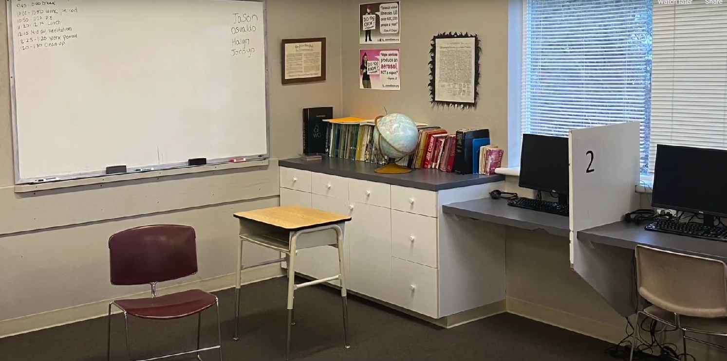 Classroom with whiteboard, books, globe, and computer workstations