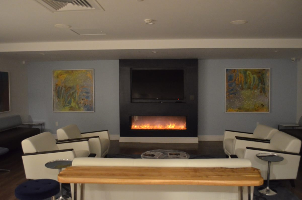 Lounge with a fireplace, TV, and modern seating.