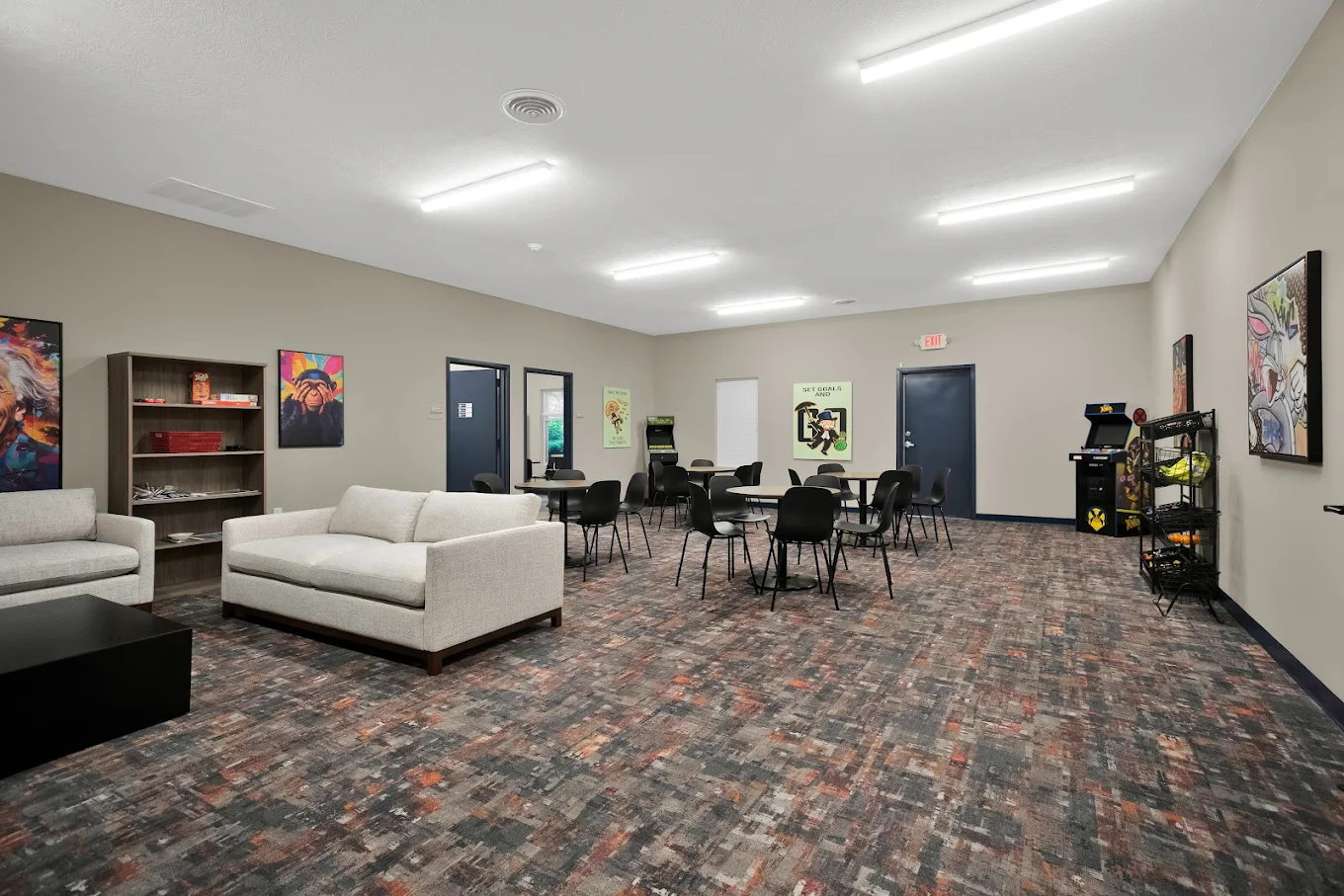 Open lounge with couches, tables, and arcade games