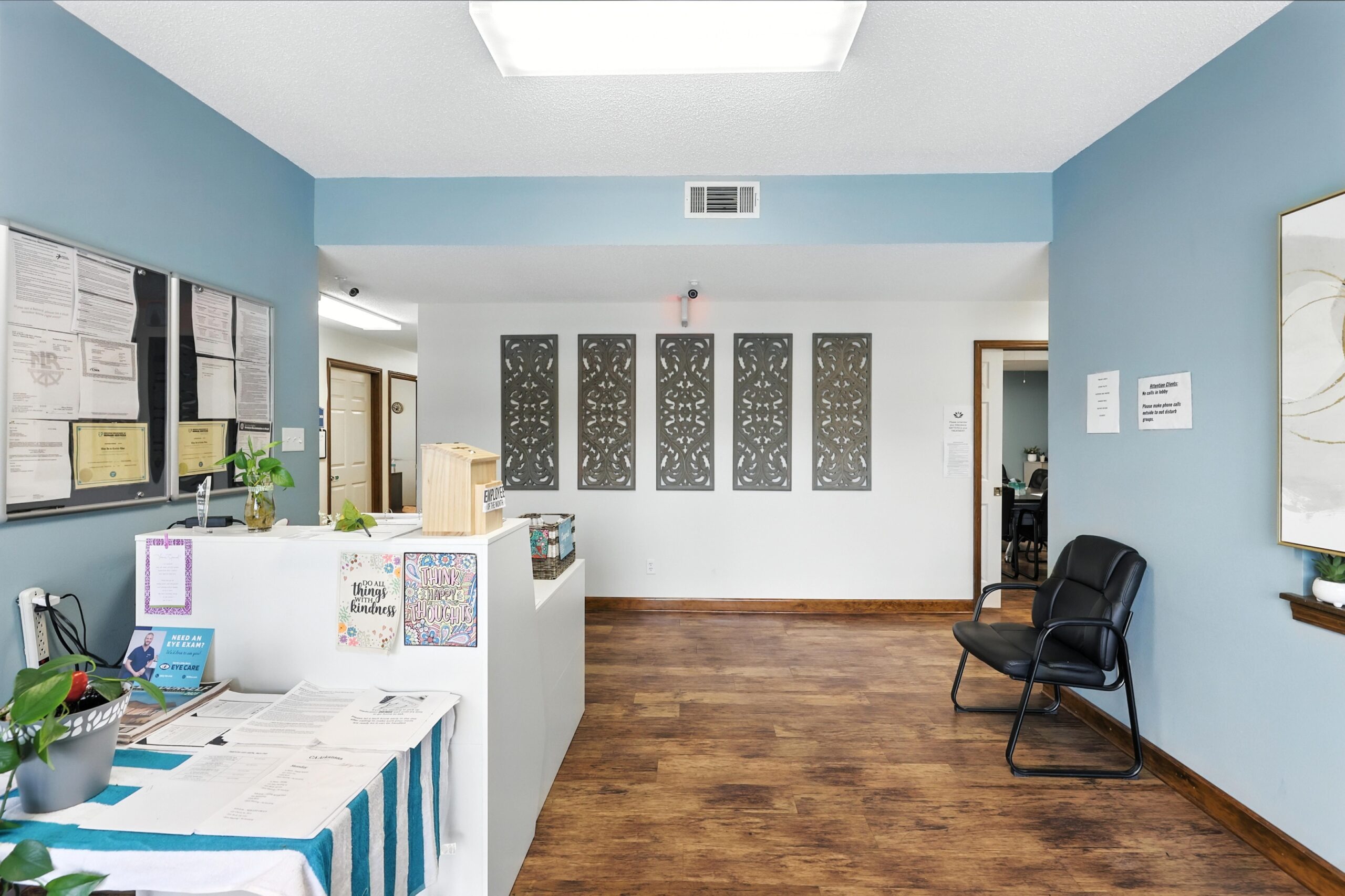 Lobby with reception desk, blue walls, wood floors, and seating.