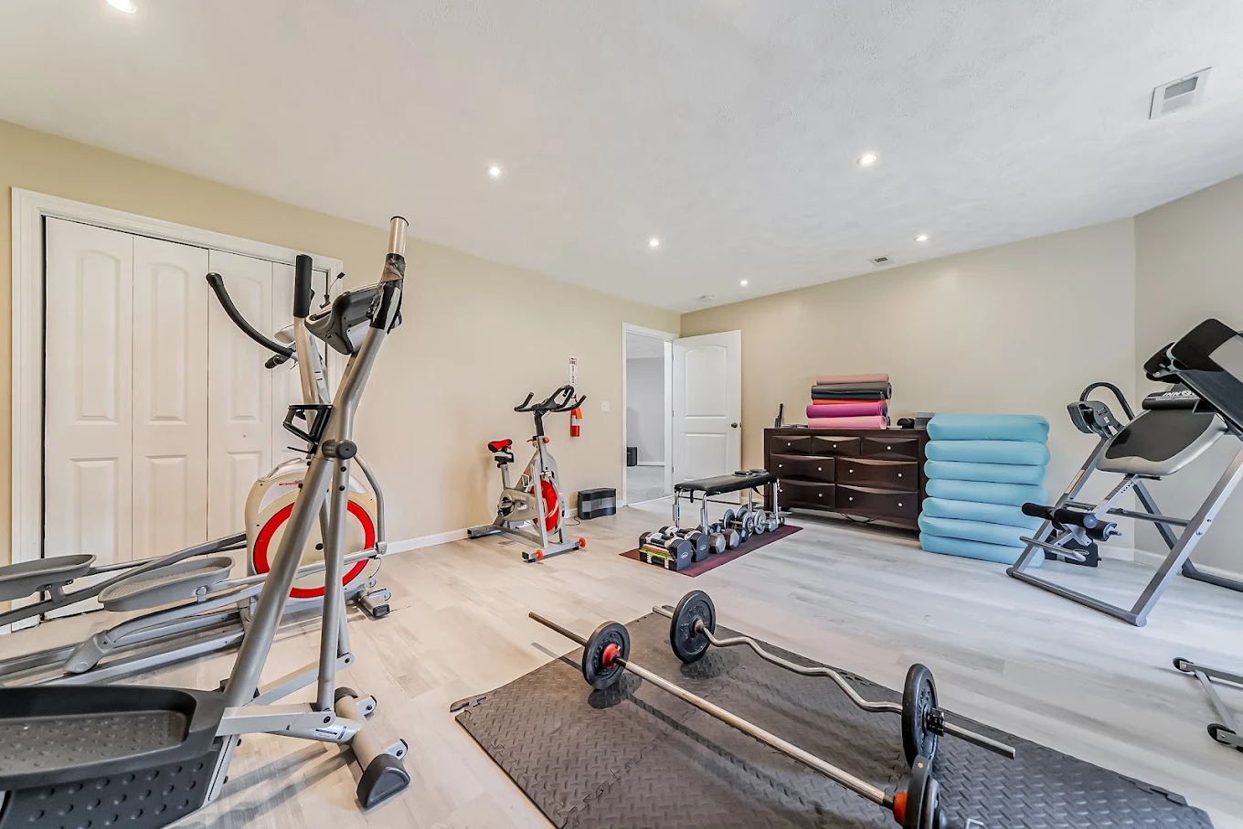 Fitness room with exercise bikes, weights, and workout mats