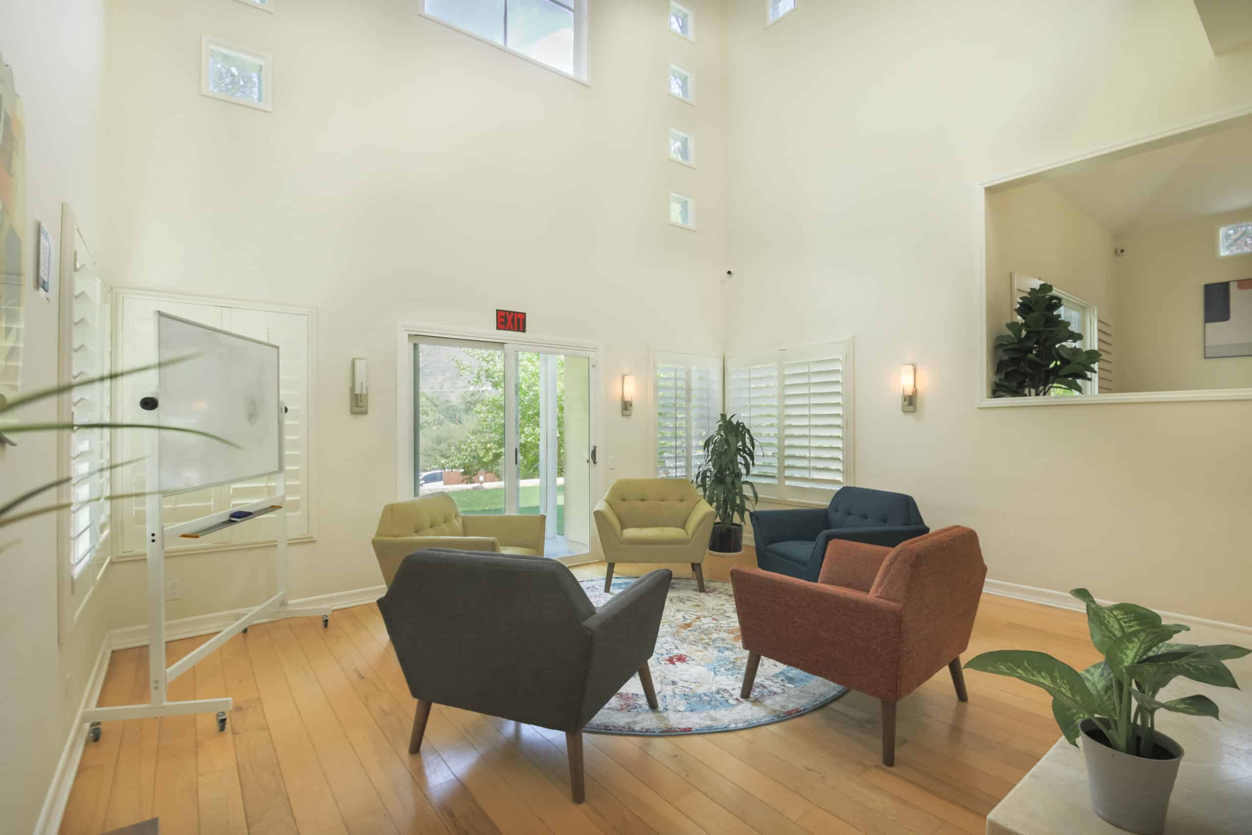 Bright group room with colorful chairs and whiteboard