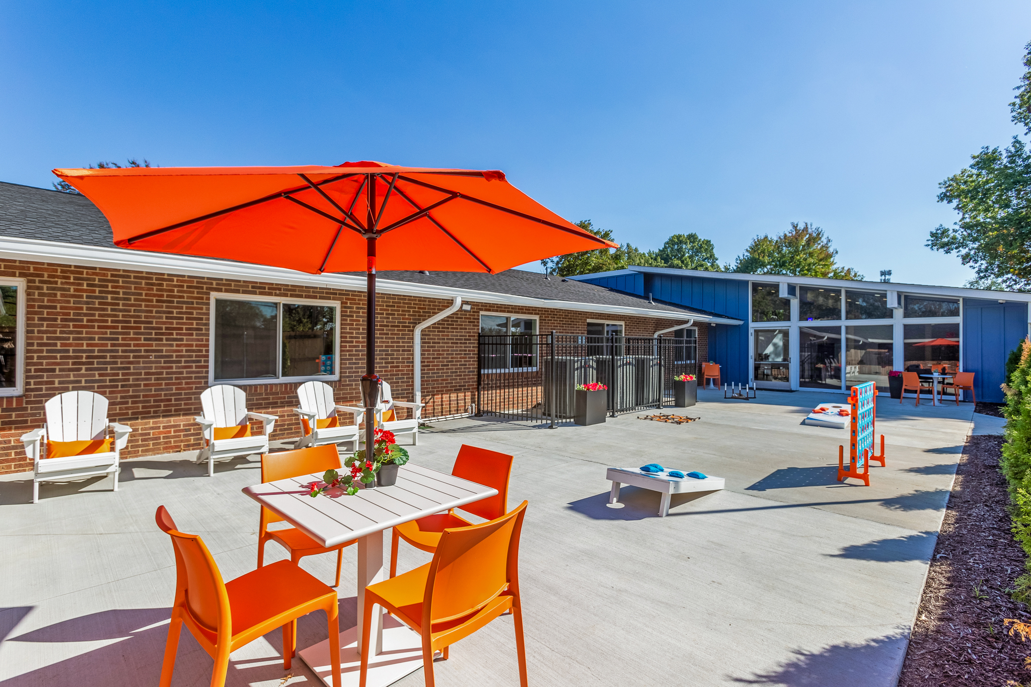 Courtyard with tables, chairs, and a large orange umbrella
