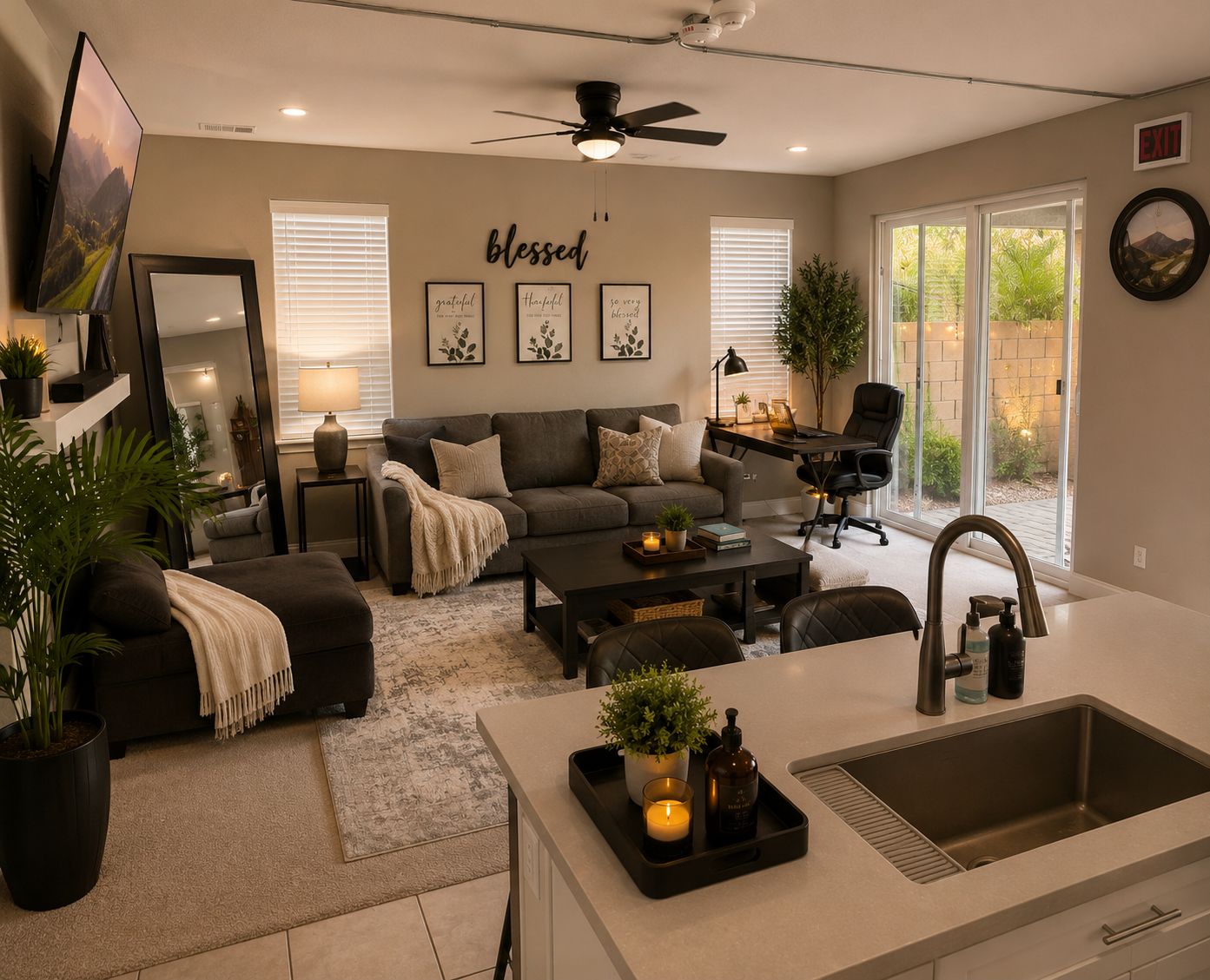 Living room with sofas, workspace, and adjoining kitchen