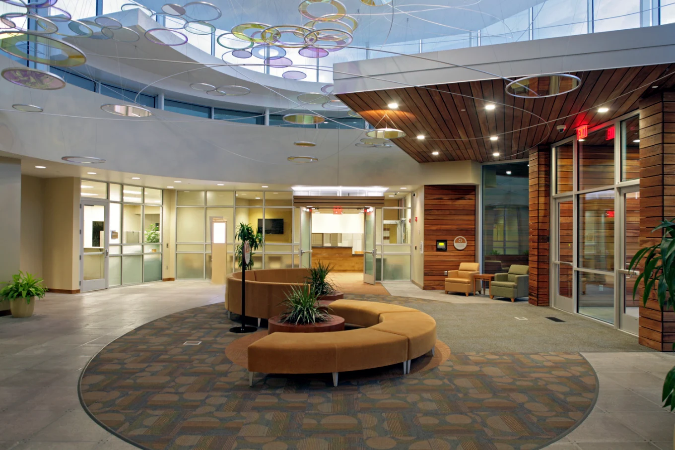 Open lobby with curved seating, plants, and glass walls