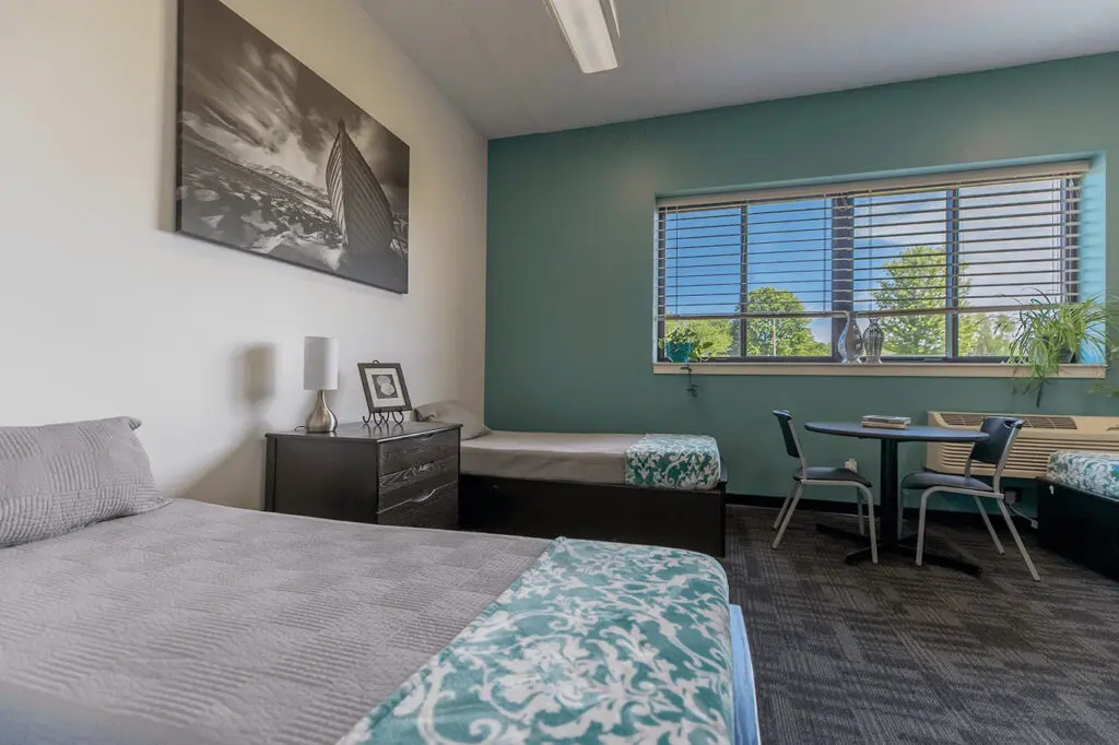 Shared bedroom with twin beds and teal accent wall