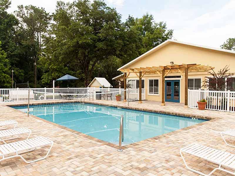 Outdoor pool with lounge chairs and fenced patio