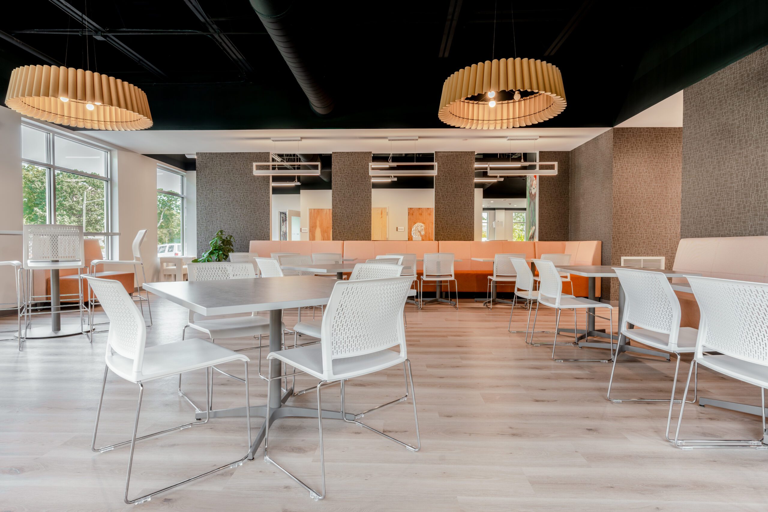 Modern dining area with tables, booths, and large windows