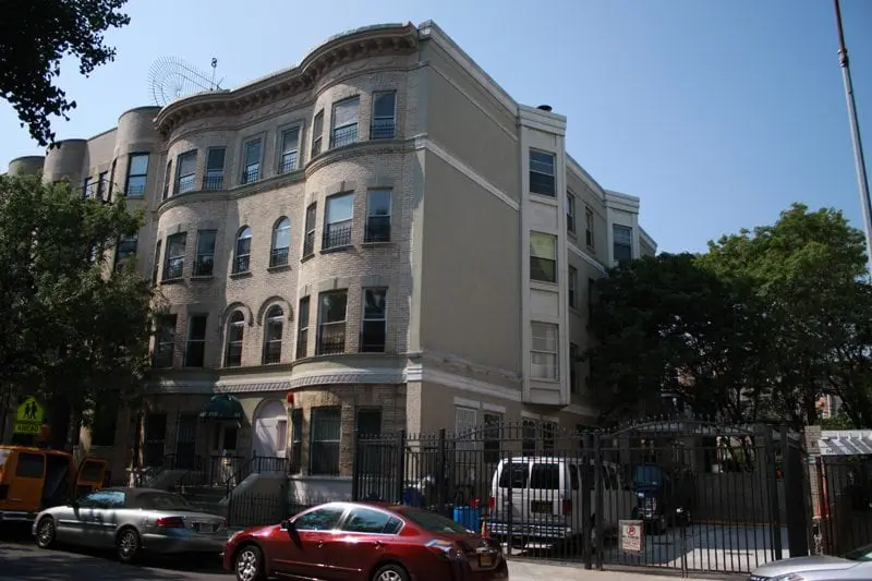 Exterior of multi-story brick building with gated entrance