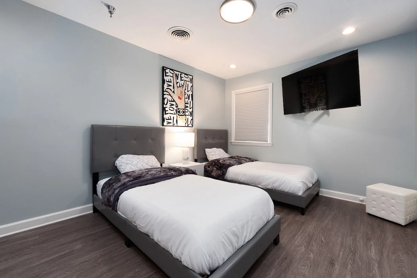 Shared bedroom with two twin beds, TV, and bedside table