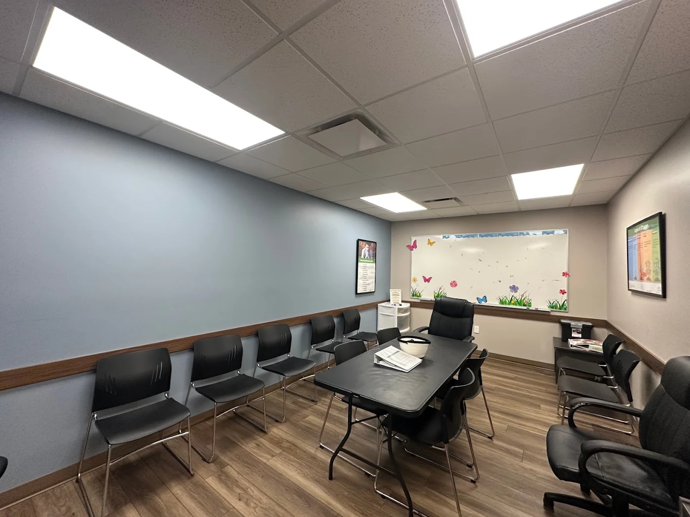 Group therapy room with table, chairs, and whiteboard
