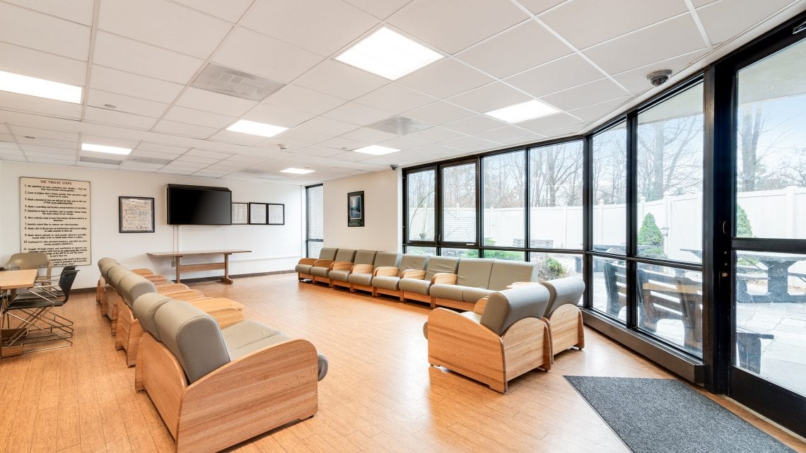Large room with rows of chairs and wall-mounted TV