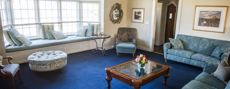 Lounge with blue sofas and bright window seating