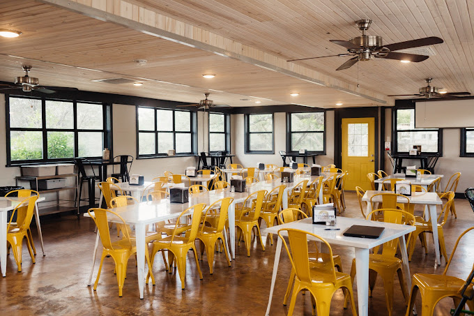 Indoor dining area with yellow chairs and ceiling fans