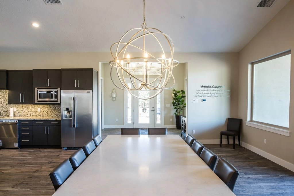 Dining table beside a modern kitchen and large windows