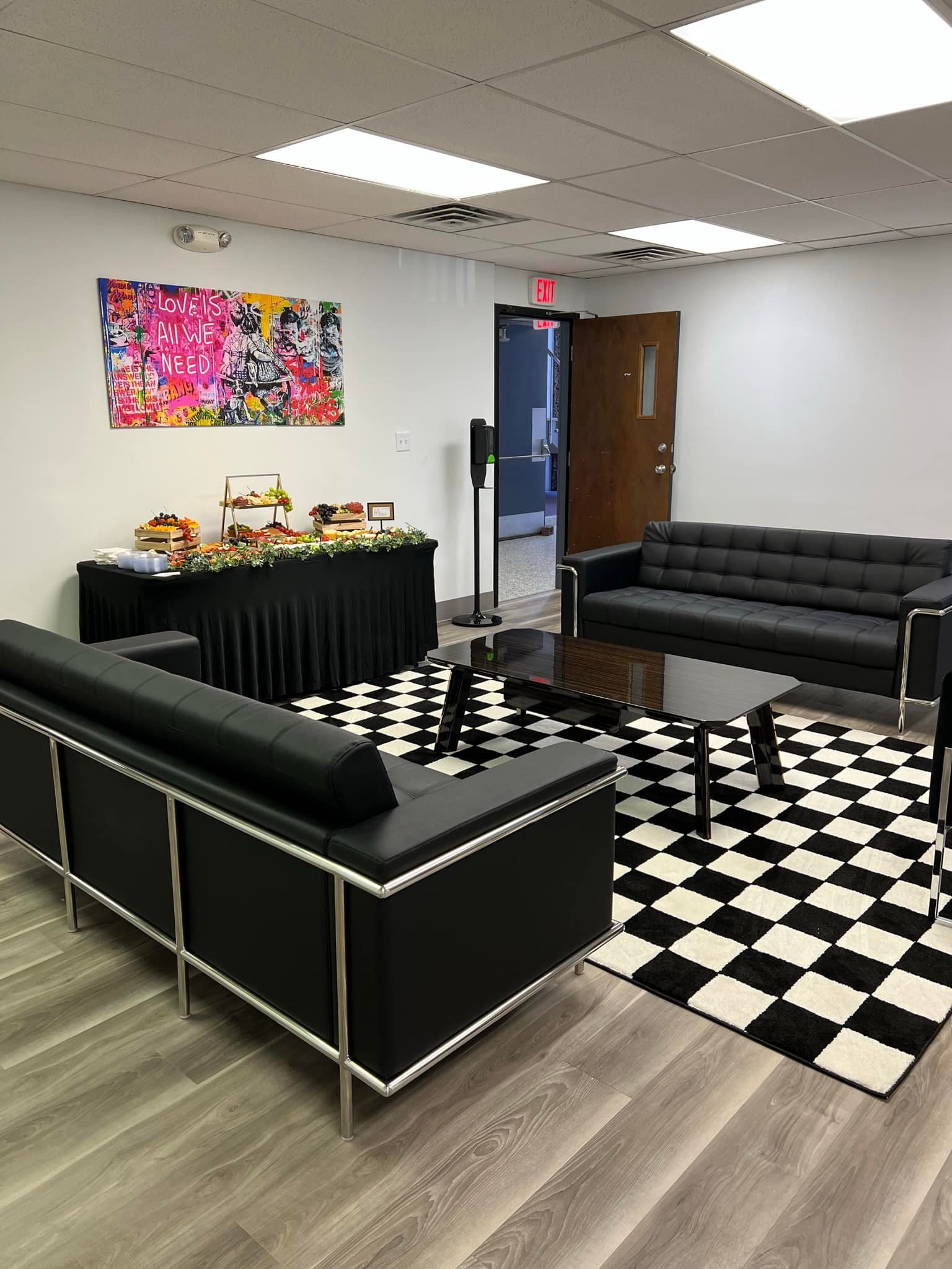 Lounge with black sofas and checkered rug